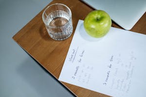 Green Apple and Glass of Water on the Wooden Table